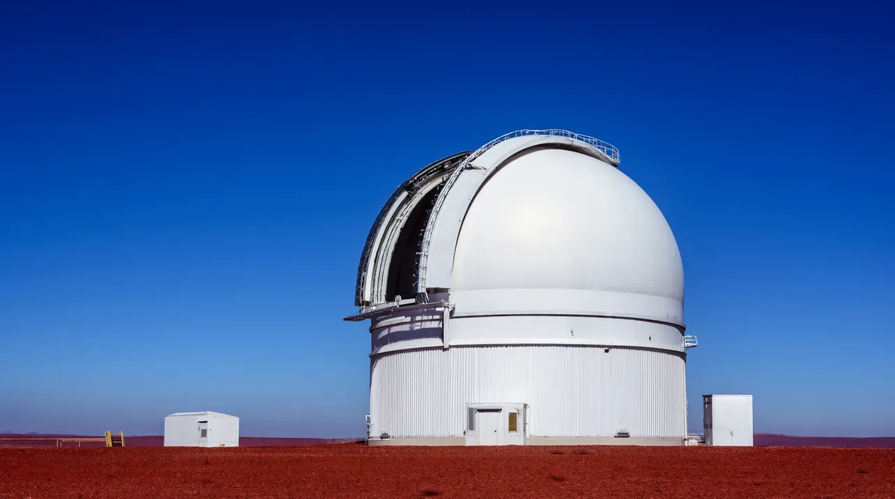 Un observatorio astronómico blanco en un desierto rojo bajo un cielo azul despejado.