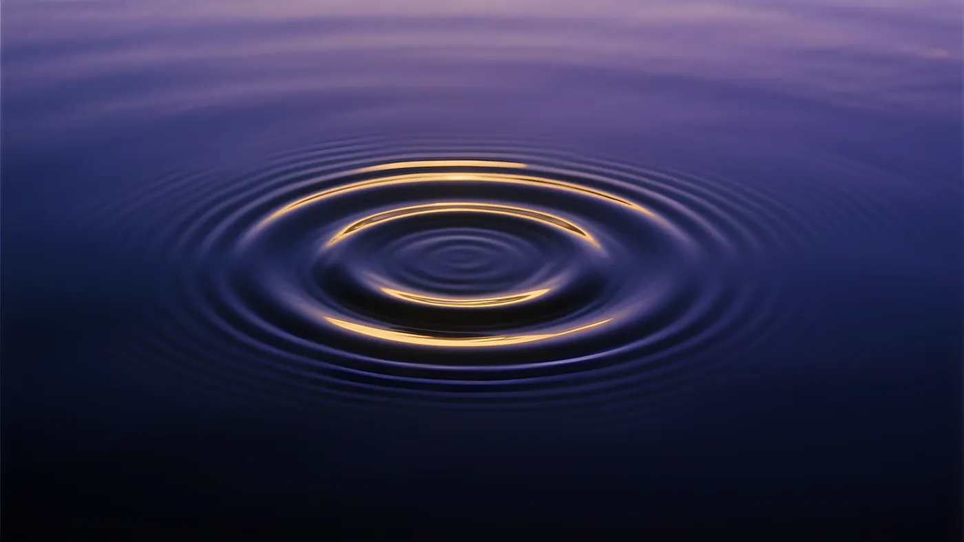 Ondas concéntricas que se abren despacio sobre un agua en calma
